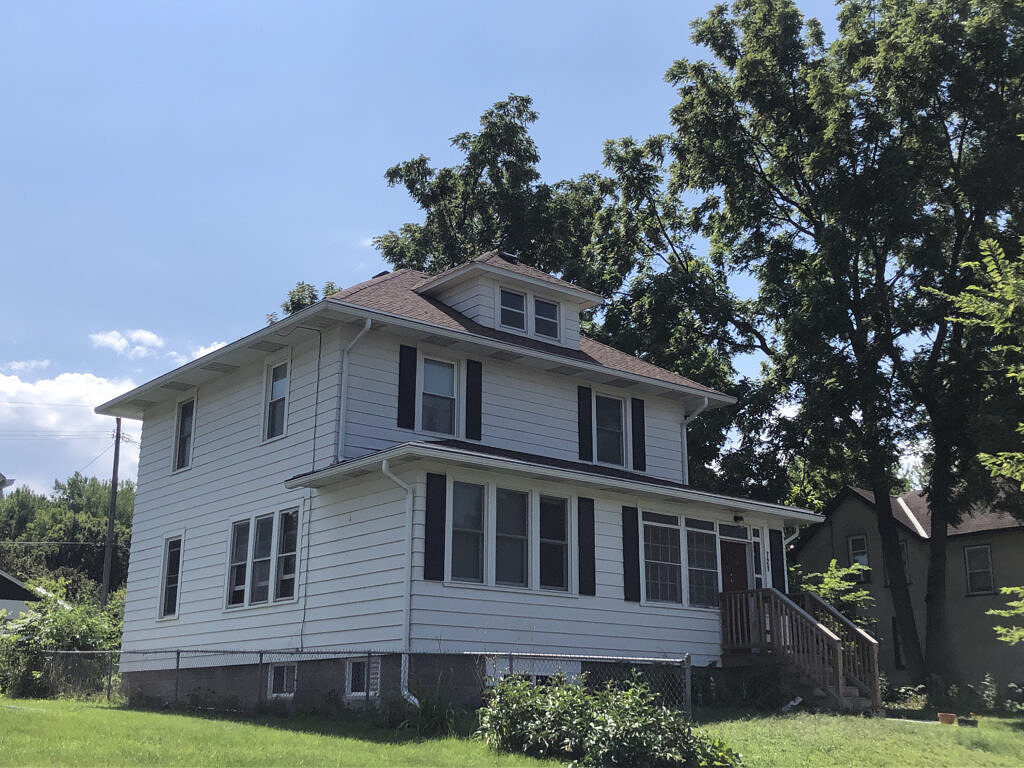 House with white siding and Shake colored shingles.