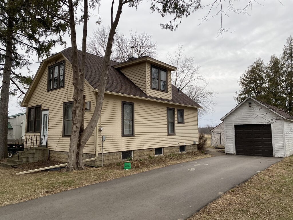 one and half story house with yellow siding.